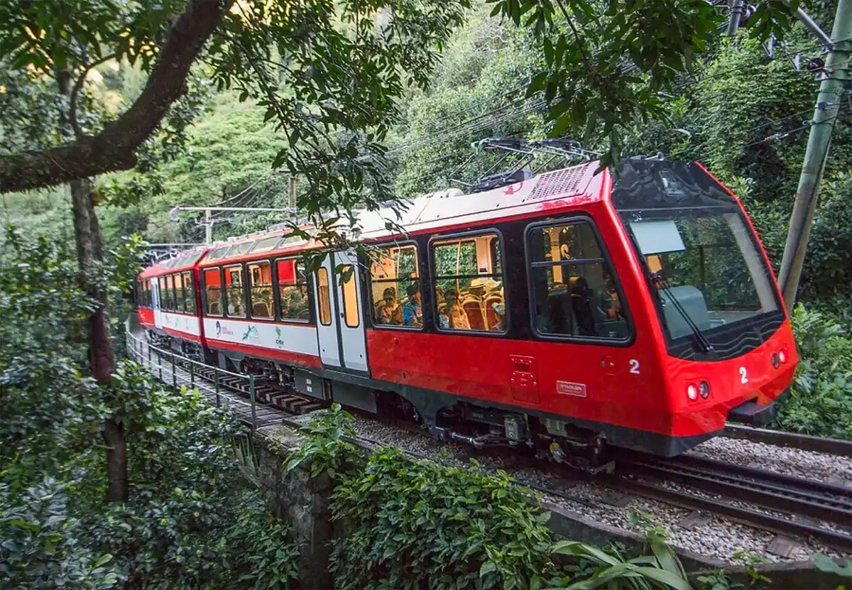 Red Corcovado cog train climbing through Tijuca Forest, the ride included with many christ the redeemer tickets in Rio de Janeiro