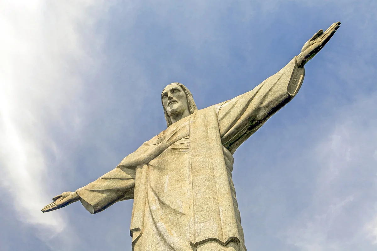 Christ the Redeemer statue with outstretched arms above the clouds, the view that christ the redeemer tickets unlock in Rio de Janeiro
